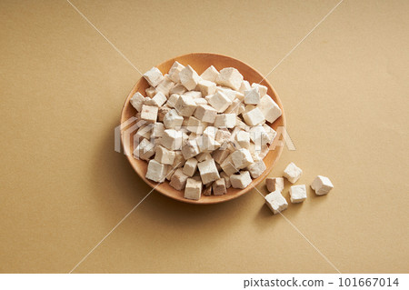 A plate of Chinese medicinal herbs of wolfiporia extensa or poria cocos on round dishes on light brown background. Herb has many effects: anti-oxidant, anti-cancer, anti-viral 101667014