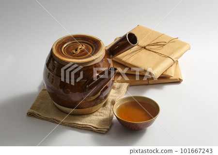 An earthen pot with a bowl of medicine placed on white background with some packs of traditional medicine. Natural medicine content 101667243