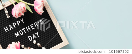 Spring season still life with pink tulips and Happy Mother's day text on letter board top view 101667302
