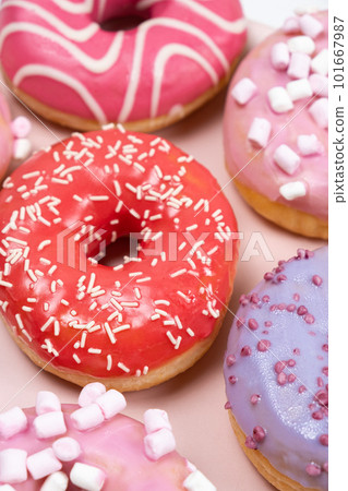 Donuts with red and pink glaze, top view. Lots of donuts, sweet and delicious food Donuts with red and pink glaze, top view. Lots of donuts, sweet and delicious food 101667987