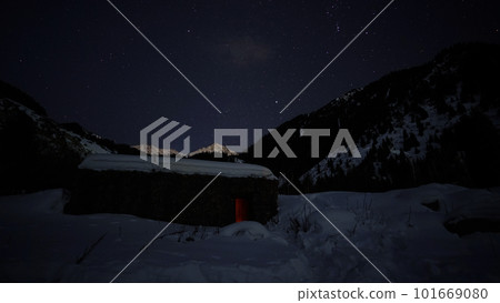 The night starry sky and a hut in the mountains 101669080