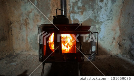 A fire in a camping stove with a glass door. A fire in a camping stove with a glass door. 101669086
