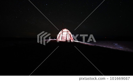 A tent with a stove stands under the starry sky. A tent with a stove stands under the starry sky. 101669087