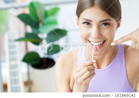 Cleaning teeth with dental floss, perfect healthy tooth 101669142