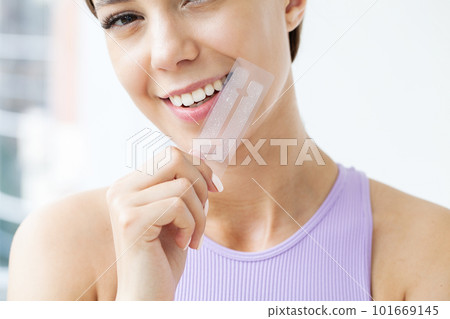 Beautiful Young Girl With White Teeth Holding in Hands Stripes For Teeth Whitening. 101669145