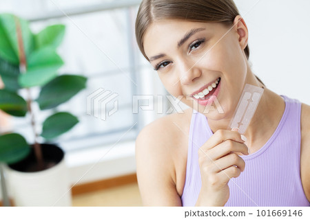 Beautiful Young Girl With White Teeth Holding in Hands Stripes For Teeth Whitening. 101669146