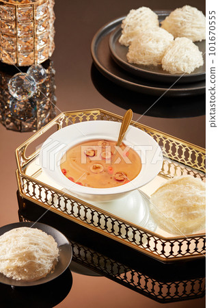 A ceramic bowl filled with bird nest soup, jujube and dried goji berries, decorated with edible bird nest. Bird nest and herbs is a combination of healthy food A ceramic bowl filled with bird nest soup, jujube and dried goji berries, decorated with edible bird nest. Bird nest and herbs is a combination of healthy food 101670555