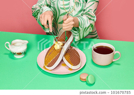 Female hands cutting with fork and knife surreal waffles sneakers with melting butter and honey against pink studio background Female hands cutting with fork and knife surreal waffles sneakers with melting butter and honey against pink studio background 101670785