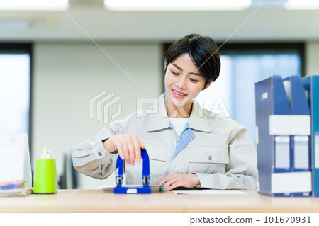 Business woman wearing work clothes punching a hole 101670931