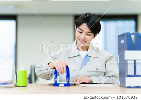 Business woman wearing work clothes punching a hole 101670932