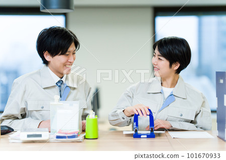 Men and women wearing work clothes punching holes 101670933