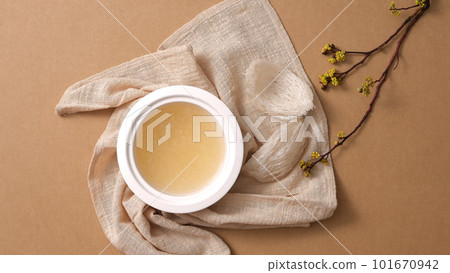 Top view of Edible bird nest raw and soup, white handkerchief and flower branch on brown background. Healthcare food, popular at Vietnam Nam, China and Southeast Asia. Top view of Edible bird nest raw and soup, white handkerchief and flower branch on brown background. Healthcare food, popular at Vietnam Nam, China and Southeast Asia. 101670942