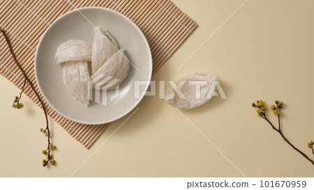 Top view of raw bird nest neatly arranged in round dishes, small flower branches on beige background. Bird nest is an expensive culinary ingredient for health - Healthy food. Top view of raw bird nest neatly arranged in round dishes, small flower branches on beige background. Bird nest is an expensive culinary ingredient for health - Healthy food. 101670959