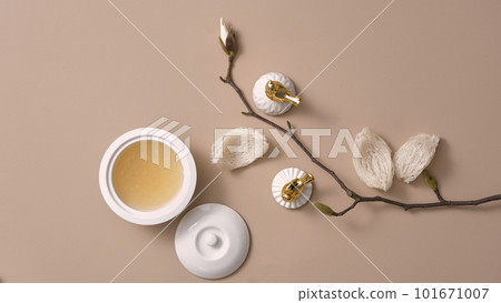 Flat lay of bird nest soup contained in a porcelain bowl, decorated with edible bird nest and a flower branch. Bird nest is a expensive and high-class dessert 101671007