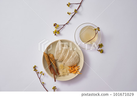 A dish of edible bird nest with herbs, ginseng, cordyceps, rock sugar and bird nest soup contained in a glass cup. Bird nest can promote eye health 101671029