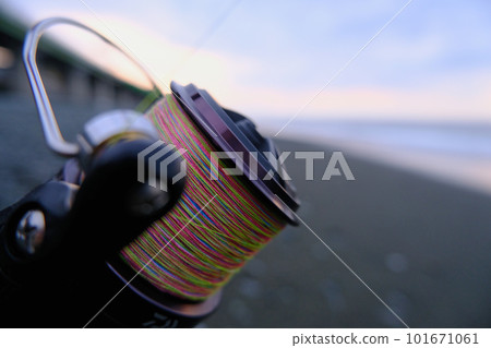 A reel wrapped with PE line, used on the beach in the early morning. 101671061
