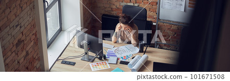 High angle view of tired woman touching her temples, having a stong headache while working on new project, using pc in modern office High angle view of tired woman touching her temples, having a stong headache while working on new project, using pc in modern office 101671508