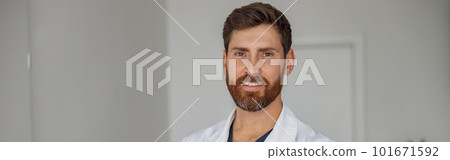 Portrait of smiling doctor in uniform standing in medicine clinic hall and looking camera 101671592