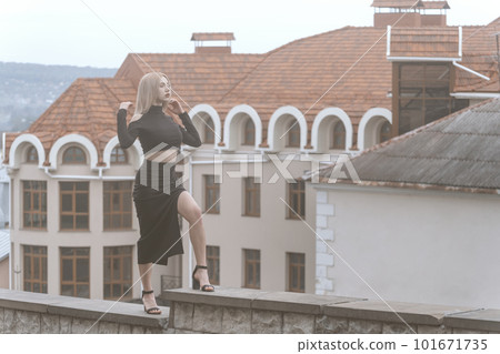 Young sexy woman stand on ancient architecture background. Stylish woman in black outfit and heels. Young sexy woman stand on ancient architecture background. Stylish woman in black outfit and heels. 101671735