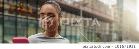 Young healthy sporty woman using cell phone during rest after jog. Blurred background Young healthy sporty woman using cell phone during rest after jog. Blurred background 101671931