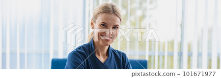 Smiling doctor working laptop during appointment in her medical office and looking camera Smiling doctor working laptop during appointment in her medical office and looking camera 101671977