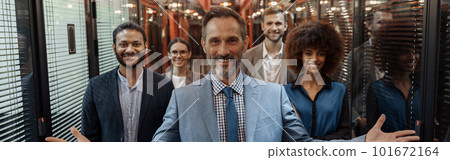 Group of happy, motivated business people standing together at office with their leader Group of happy, motivated business people standing together at office with their leader 101672164