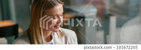 Cheerful businesswoman in jacket use phone during working in cafe near window. Distance work concept Cheerful businesswoman in jacket use phone during working in cafe near window. Distance work concept 101672205