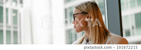 Busy businesswoman in glasses drinking coffee and making notes while working in cafe 101672215