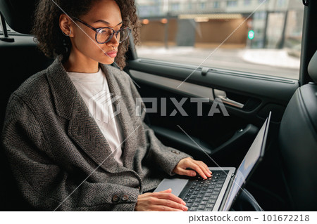 Focused businesswoman acountant working on laptop sitting car backseat on the way to office 101672218