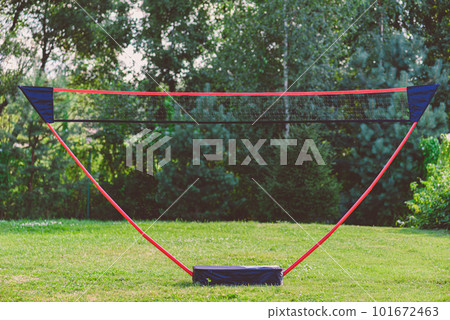 Portable badminton net and playing set at backyard lawn on summer day Portable badminton net and playing set at backyard lawn on summer day 101672463