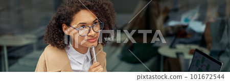 Focused Afro american woman freelancer working remotely while sitting on cafe terrace 101672544