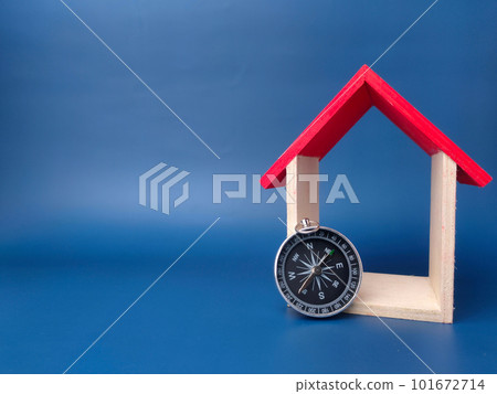 Toy house and compass on a blue background with copy space. 101672714
