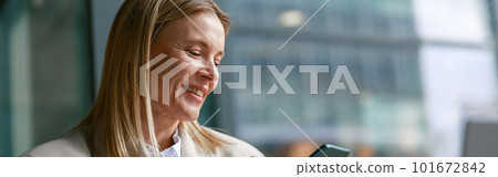Cheerful businesswoman in jacket use phone during working in cafe. Distance work concept Cheerful businesswoman in jacket use phone during working in cafe. Distance work concept 101672842