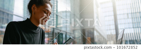 Smiling woman holding phone during working day in cafe sitting near window. Distance work concept Smiling woman holding phone during working day in cafe sitting near window. Distance work concept 101672852