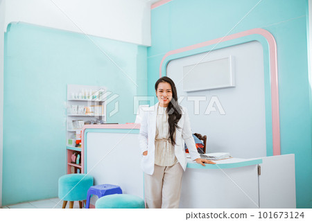 Female vet standing in front of the receptionist desk. 101673124