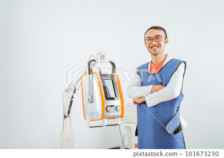 a handsome vet in x-ray protective apron smiling with crossed arms 101673230