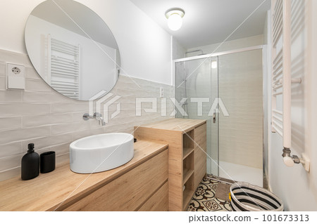 Cozy bathroom with a mirror sink and cabinets on the backdrop of a shower in a renovated apartment. The concept of a spacious bathroom for a large family Cozy bathroom with a mirror sink and cabinets on the backdrop of a shower in a renovated apartment. The concept of a spacious bathroom for a large family 101673313