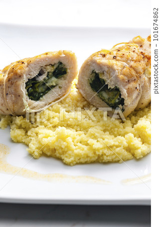 poultry roulade filled with spinach and cheese served with couscous 101674862