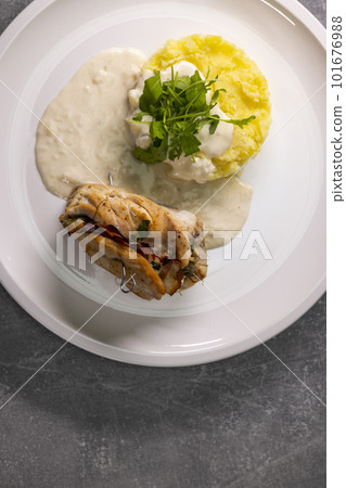 turkey roll filled with spinach and ham served with mashed potatoes and cream sauce turkey roll filled with spinach and ham served with mashed potatoes and cream sauce 101676988