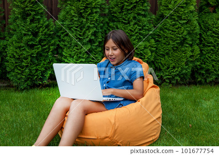 girl with a laptop in the garden 101677754