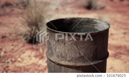 old empty rusted barrel on sand 101678025