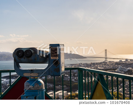 Coin-operated binoculars overlooking the Akashi Kaikyo Bridge at dusk (Hyogo Prefecture) 101678408