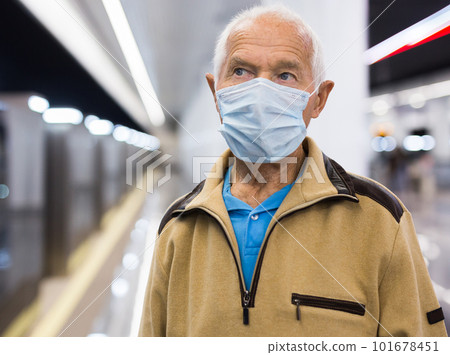 Elderly man in medical mask waiting for subway train at underground station. Necessary precautions during coronavirus pandemic Elderly man in medical mask waiting for subway train at underground station. Necessary precautions during coronavirus pandemic 101678451