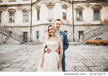 Romantic wedding moment, couple of newlyweds smiling portrait, bride and groom hugging 101679273