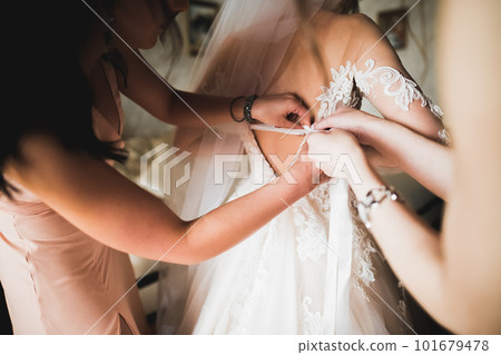 Hands of bridesmaids on bridal dress. Happy marriage and bride at wedding day concept 101679478