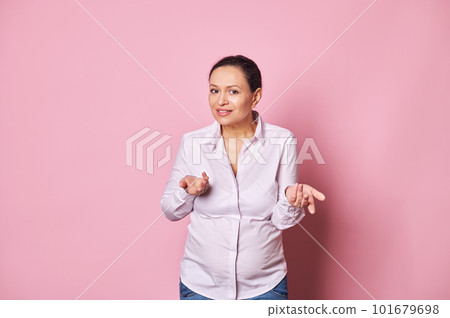 Multitasking confused middle aged pregnant woman, holding her hands palms up, asking question, expressing disappointment and misunderstanding looking at camera, isolated on pink background. Pregnancy Multitasking confused middle aged pregnant woman, holding her hands palms up, asking question, expressing disappointment and misunderstanding looking at camera, isolated on pink background. Pregnancy 101679698