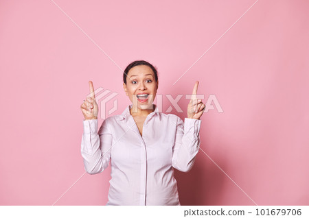 Amazed overjoyed surprised happy pregnant woman, gravid business lady pointing fingers up, posing with her mouth open, expressing amazement and positive emotions, isolated over pink color background 101679706
