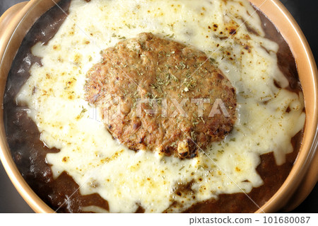 A bird's-eye view shot of hot curry with plenty of cheese and hamburger on a black background A bird's-eye view shot of hot curry with plenty of cheese and hamburger on a black background 101680087
