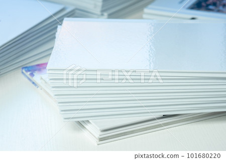 stacks of freshly printed photobooks with clean empty white covers on the table close-up 101680220