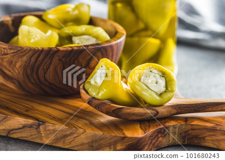 Peppers stuffed with cream cheese on wooden spoon. 101680243
